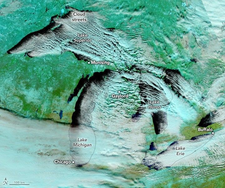 The image is colored in blue, showing snow covered land as a light blue, and clouds as a light powder blue. Cloud streets form over the great lakes and stream across the land in this image of the great lakes. Lake Ontario is partially cut off, but the remaining lakes are all visible and mostly covered by clouds.  The town of Munsing on the Upper Peninsula narrowly misses the cloud streets off of Lake Superior.  The town of Gaylord in Northern Michigan is thoroughly obscured by cloud streets.  Buffalo, at the right edge of the image  is on the cloud cover edge. Chicago is under cloud cover, but more of a typical cloud than cloud streets.