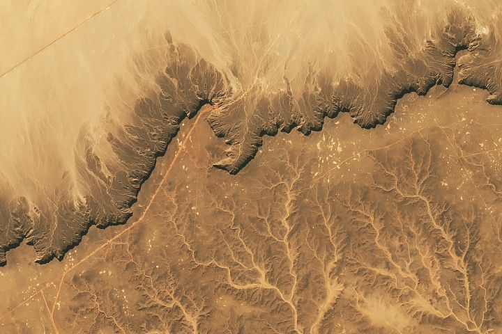 The Cretaceous sandstone of Libya’s Messak Settafet plateau shows signs of a modern oil field and Stone Age quarries and hunting sites.