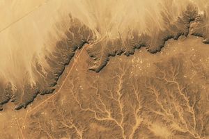 The Cretaceous sandstone of Libya’s Messak Settafet plateau shows signs of a modern oil field and Stone Age quarries and hunting sites.