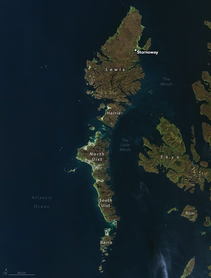 Image of island chain arc in the dark blue Atlantic Ocean. The land is a blend of green to brown shades. The water that separates these islands from more mainland areas is labeled The Minch and The Little Minch. Skye and Rum are inland islands, shown right. The archipelago consists of Stornoway on the largest land section, Lewis, and downward from there is Harris, North Uist, South Uist and finally Barra.