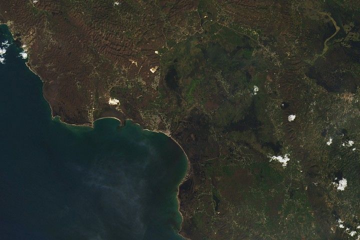 A satellite image taken after Hurricane Melissa hit shows the same area around Black River. Now the town is surrounded by a mostly brown landscape.