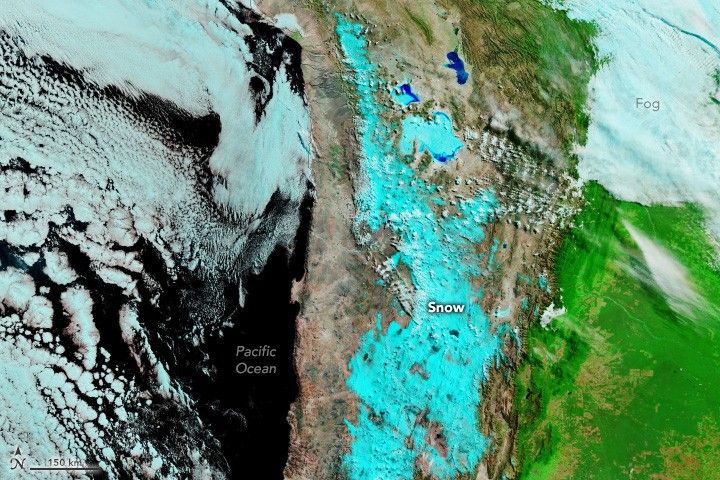The image shows the brown arid landscape of the West coast of South America covered in a bright blue snow, the near black Pacific Ocean is visible on the left. To the right the region appears bright green with a light blue region in the upper right labeled fog.
