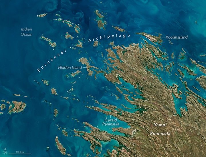 in the light blue Indian Ocean there is a stretched smattering of islands, diagonally toward the upper left, labeled the Buccaneer Archipelago. Hidden island is near the image center and the Koolan Island is at the Northmost end of the region. Ther Gerald peninsula stretches toward the Indian ocean in the lower center. The Yampi Peninsula is the main portion of land in this image, it and the islands are all a light brown shade with some small smatterings of vegitation along the coastlines, particularly where there are valleys.