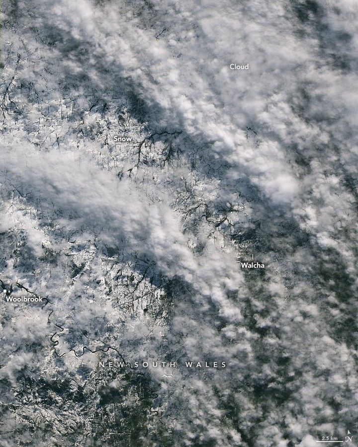 White snowy landscape of New South Wales, including Walcha and Woolbrook are partially obscured by white puffy clouds.