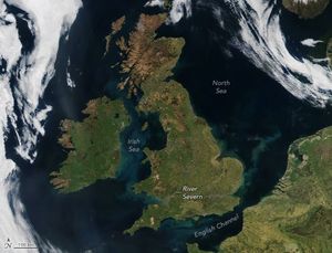 Satellite image of the UK, Ireland, and northern France. The Irish Sea between the two large island countries is labeled and light in color compared to the surrounding deep blue waters. The English Channel at the bottom of the screen is also light in color when compared to the North Sea toward the right of the UK. Clouds swirl over the ocean surrounding the two island nations.