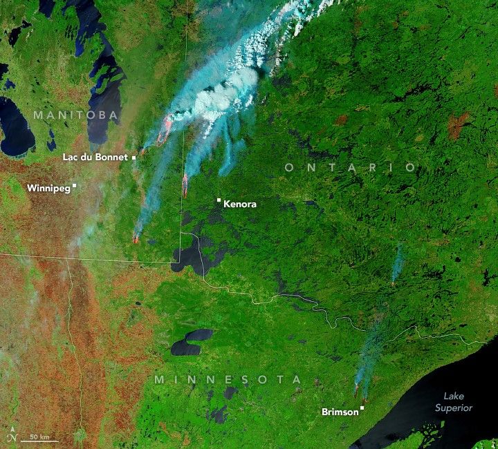 At the border of Canada and the US, specifically Minnesota, the green landscape is interrupted by dots of orange fire and smoke emanating from those fires. There are a few small fires just North of Brimson in Minnesota. The remaining fires are in Canada along the border of Ontario and Manitoba. The fires are mostly just right of Lac du Bonnet in stretch streaks of burned land.