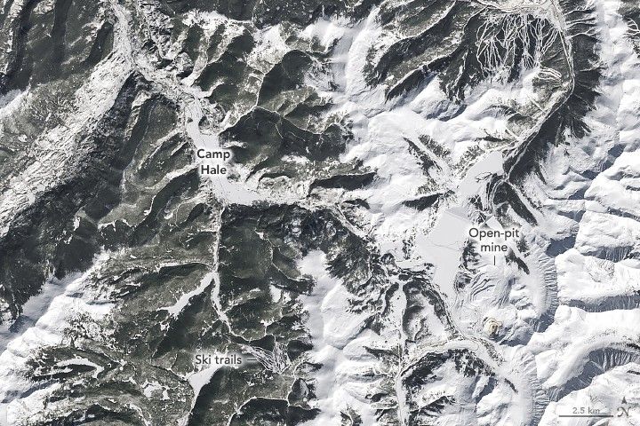 The image shows snow covered mountainous landscape with the land more gray slopes than white blankets of snow. An open pit mine is labeled in the lower right section of the image, and Camp Hale is labeled just left of center at the peak of a ridgeline. Camp Hale has a broad degree of snow coverage compared to the remaining left side of the image. Ski trails are labeled in the lower middle of the image.