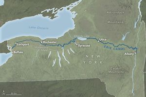 Map of New York state highlights the path of the Erie Canal in dark blue, traversing through Lockport Rochester, Oneida Lake, Utica and terminating at Albany.