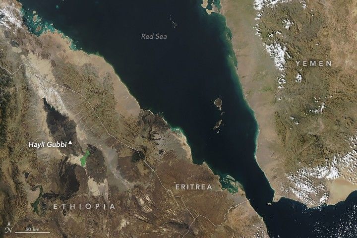 A satellite image shows parts of Ethiopia and Eritrea on the left, the Red Sea in the center, and Yemen on the right. Most of the land appears dry and in shades of light brown. A label indicates the location of the Hayli Gubbi volcano in Ethiopia amid an area of darker volcanic rock.