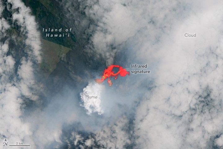 a small amount of land appears in the upper left , but is mostly obscured by cloud and smoke. The very center of the image is bright orange, an infrared signature of the heat of the volcano on the island of Hawai'i. Down and to the left of the infrared signature a particularly vibrant white cloud is labeled as a plume.