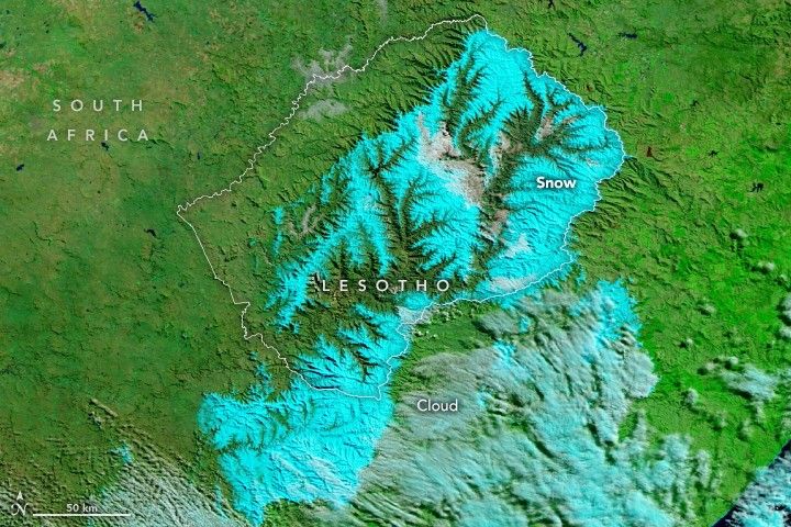 The image shows the landscape primarily in vibrant green, however, where the elevation of the landscape rises with craggy mountains and valleys, in and around Lesotho, the land is colored bright blue and labeled as snow. A pale light blue is also seen in the lower right portion of the image and labeled clouds.