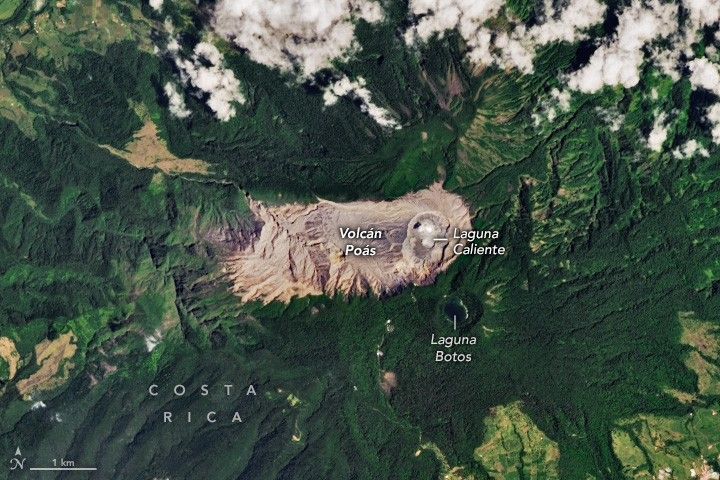 Volcán Poás is labeled in the image center, a horizontally stretched rough rectangle of tan rock surrounded primarily by deep green foliage. On the right end of the tan rock region a slight crater is labeled Laguna Caliente. Just below Laguna Caliente in the deep green foliage is a dark spot labeled Laguna Botos. The surrounding Costa Rica landscape appears to have numerous peak ridges and valleys leading away from the volcano.