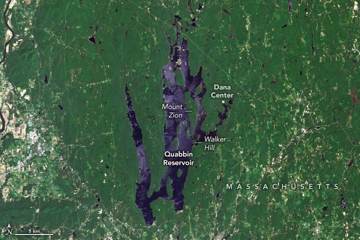 vertical stretched streaks of blue make up the Quabbin Reservoir in the surrounding green foliage of Massachusetts. Mount Zion is in the midst of the reservoir along the right side. Walker Hill is on the edge of the reservoir just below Mount Zion and the Dana Center is on the edge of the upper rightmost branch of the reservoir.