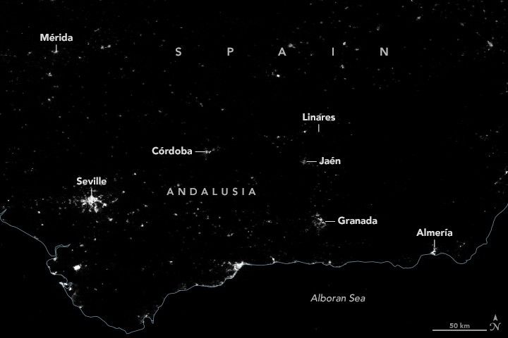 A dark image with an outline border for the country of Spain dividing it from the Alboran Sea at the bottom of the image. Left to right the following cities are labeled Mérida, Seville,  Córdoba, Linares, Jaén, Granada, and Almería. The city lights of these cities are all less bright than normal, Linares lights are completely missing.
