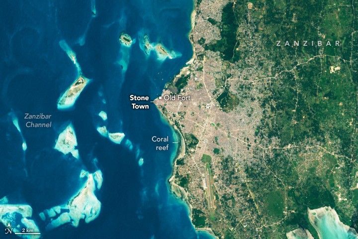 The coastline of Zanzibar shows the highly settled area surrounding Stone Town. Inland areas are covered with green foliage primarily, but there are signs of human settlement along the inland roads. A coral reef is highlighted on the coast below Old Fort. A few islands reside off the coast in the Zanzibar channel.