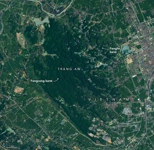Deep green variable elevation foliage dominates the center of the image labeled Fengcong Karst. To the right some buildings and roads divide this from the nearby smaller but similarly landscaped area labeled fenglin Karst. At the right edge of the image is a densely built up area, the remainder of the image is relatively sparse human settlements and roads with more moderately green colored fields.