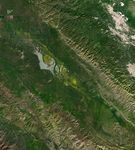 Wildflower blooms appear as yellow patches at the center of satellite images centered on Carrizo Plain National Monument. The blooms spread and intensify between March 5 and March 13.