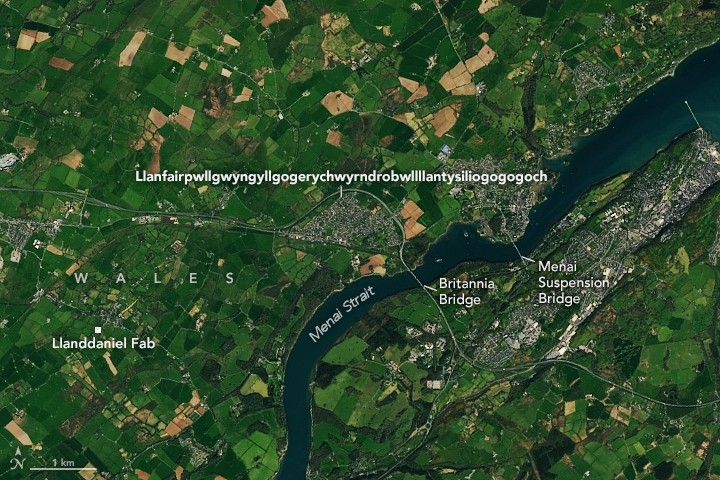 The long-named town in Wales appears as a gray patch amidst a bucolic image with green farmland bordering the Menai Strait. Two bridges mark an area known for treacherous whirlpools.