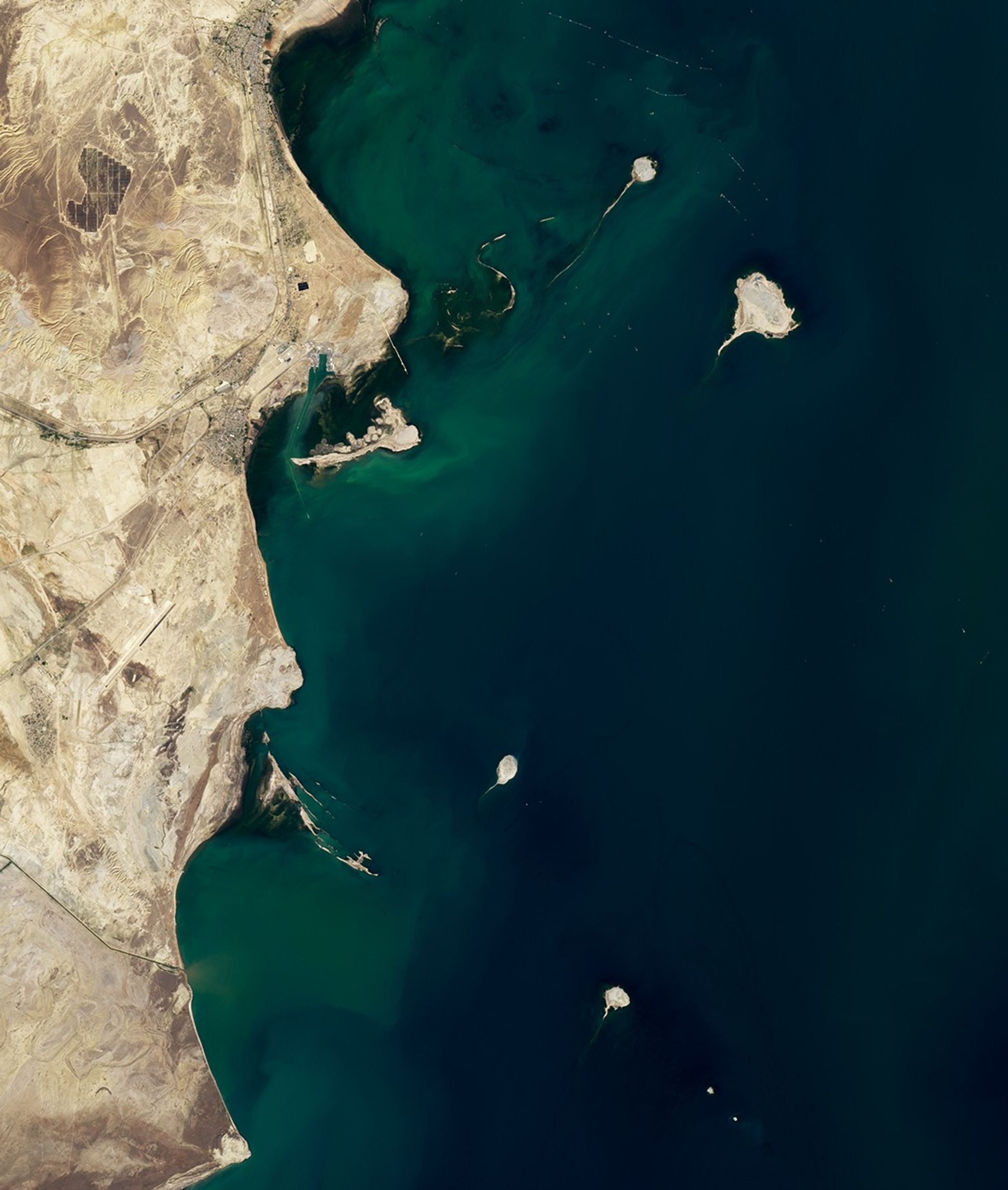 Islands appear as small brown patches against the blue waters of the Caspian Sea. The brown coastline of Azerbaijan covers the left side of the image.
