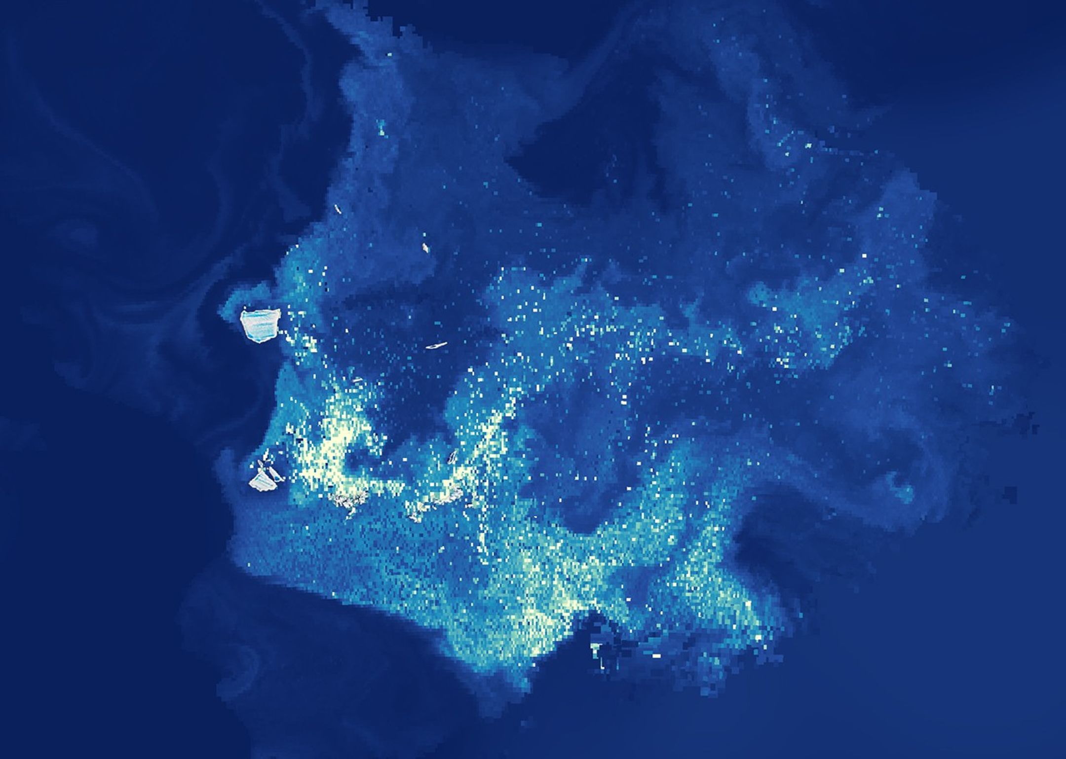 A map of the same area shows chlorophyll-a plumes appearing to emanate from many icebergs scattered throughout the region. Plumes with higher concentrations of chlorophyll-a—a proxy for phytoplankton—appear in lighter shades and dissipate as they drift and swirl in ocean currents.