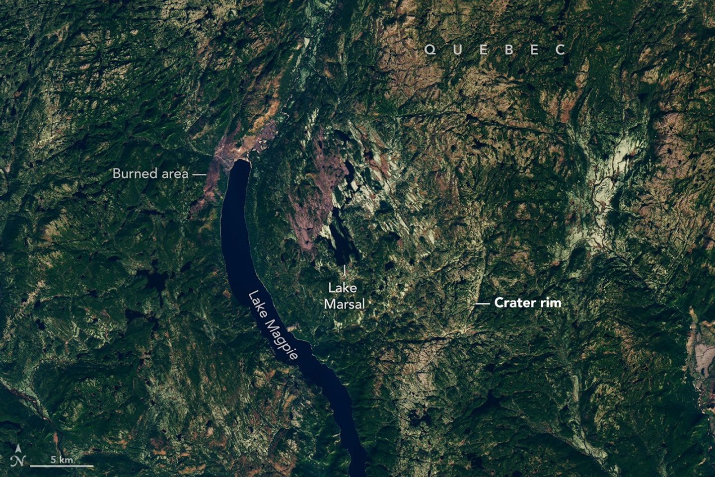 Though subtle, a circular indentation with Lake Marsal near the center is visible in the middle of a mostly green landscape with textured terrain and many lakes.