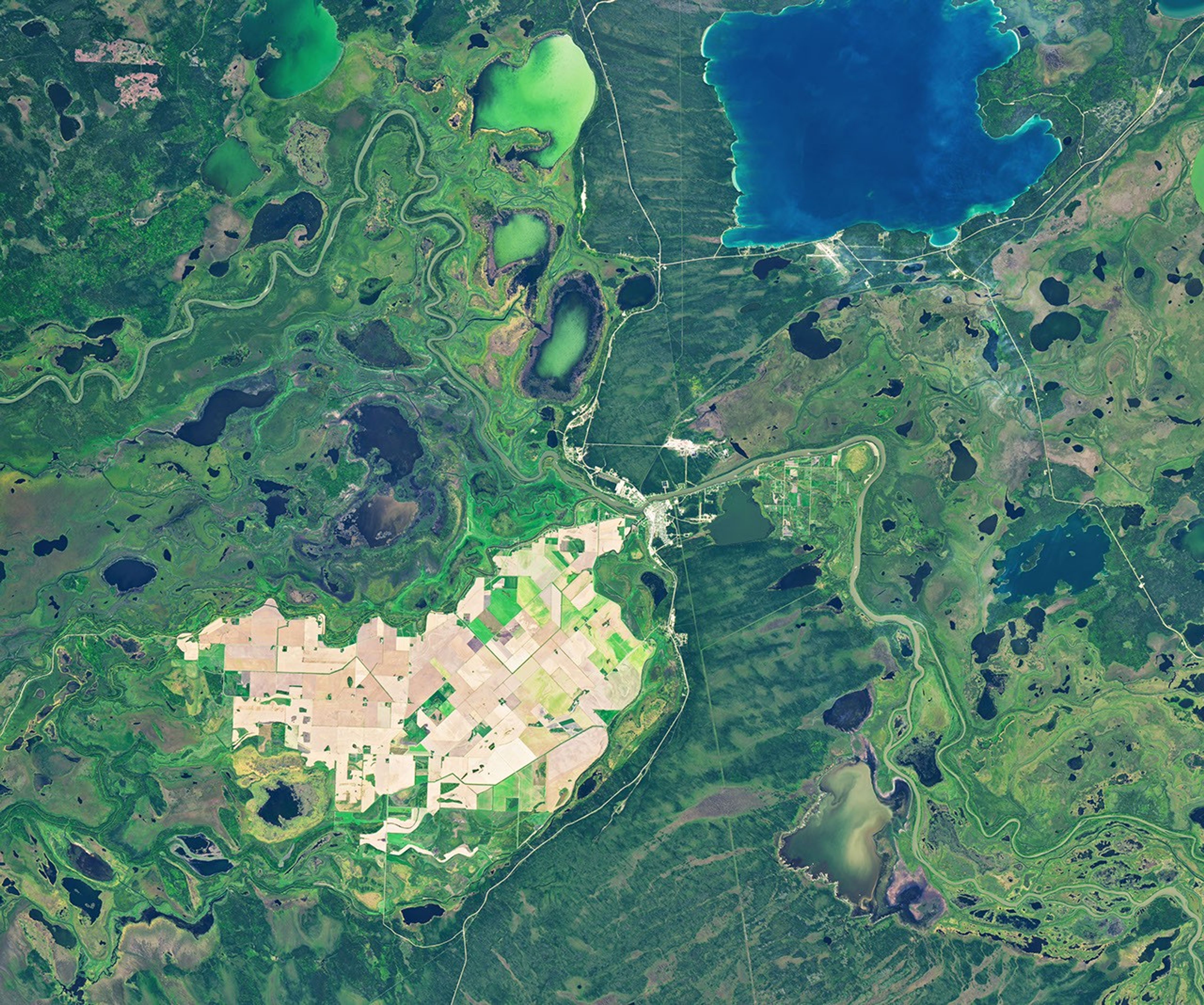 The same area in autumn shows many of the farm fields are now brown, and the surrounding wetlands hold less water.