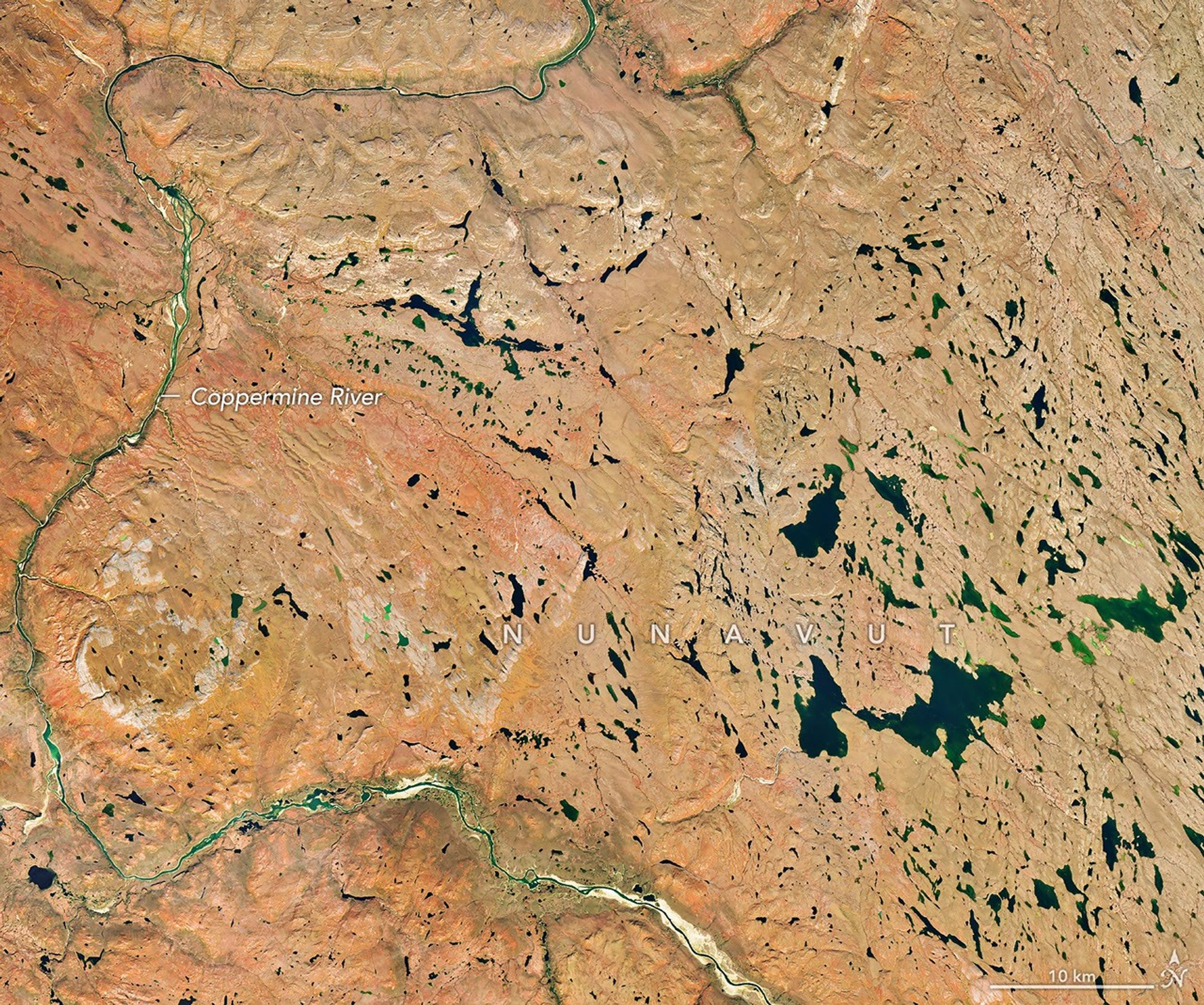 A river winds through the same tundra landscape in autumn, now colored red and orange. Some green vegetation remains visible along the river.
