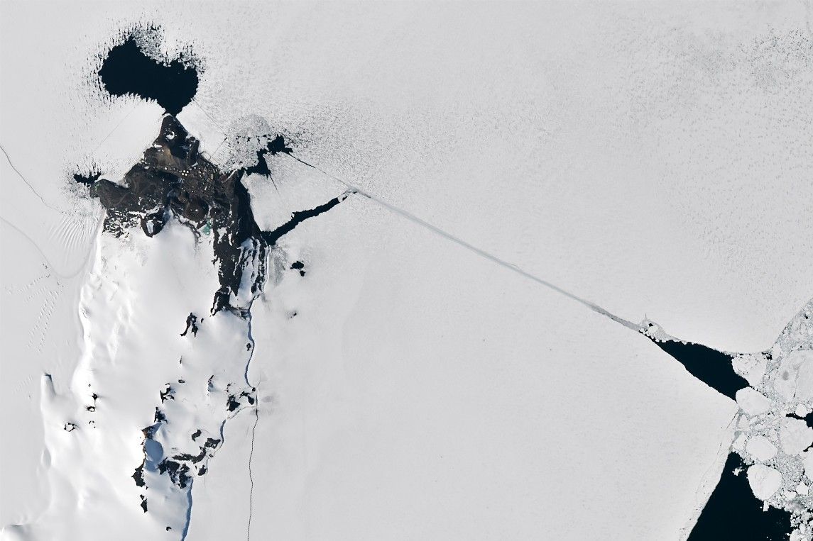 A satellite image of the same area shows a completed channel cut by an icebreaker through the sea ice. The ship channel stretches about 10 kilometers from open water on the right to McMurdo Station on the left.