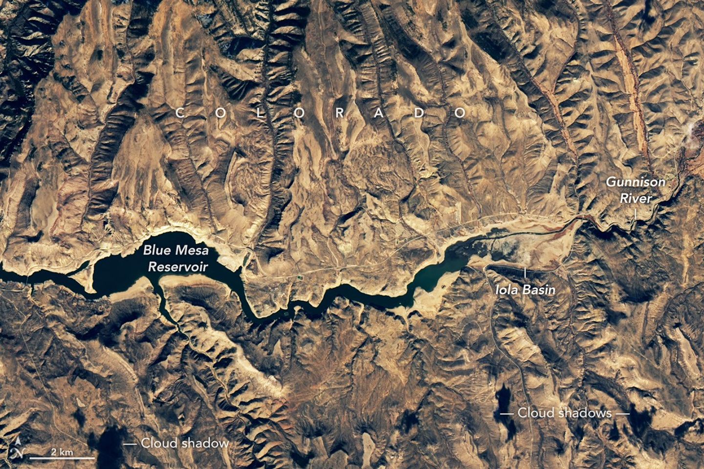 The second image in the pair shows the same part of the reservoir in November 2021, when water levels were much lower and its color was much greener.