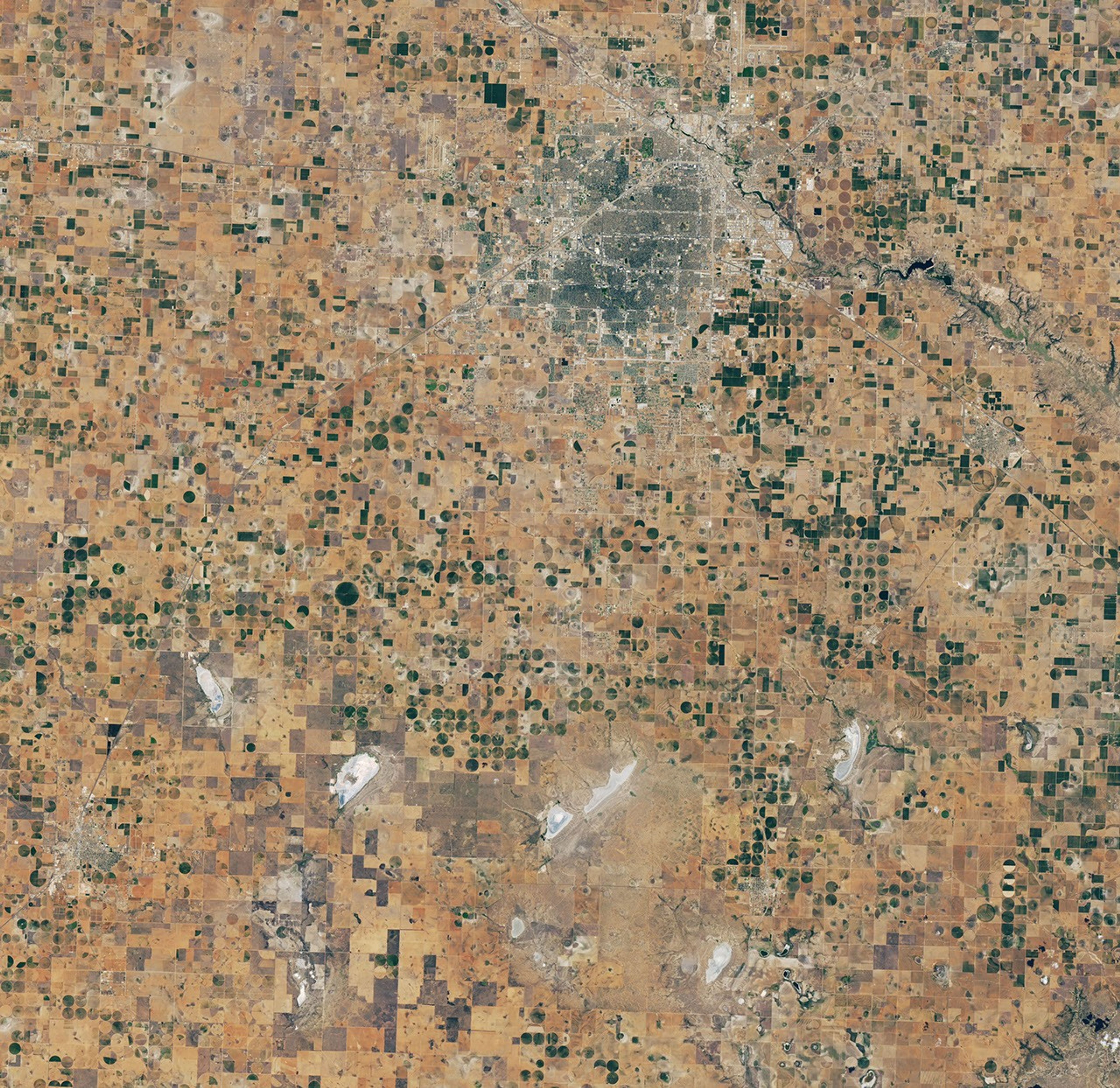 A satellite image of the same Lubbock region on September 9, 2026, appears parched, with much less green vegetation and mostly dry lakes.