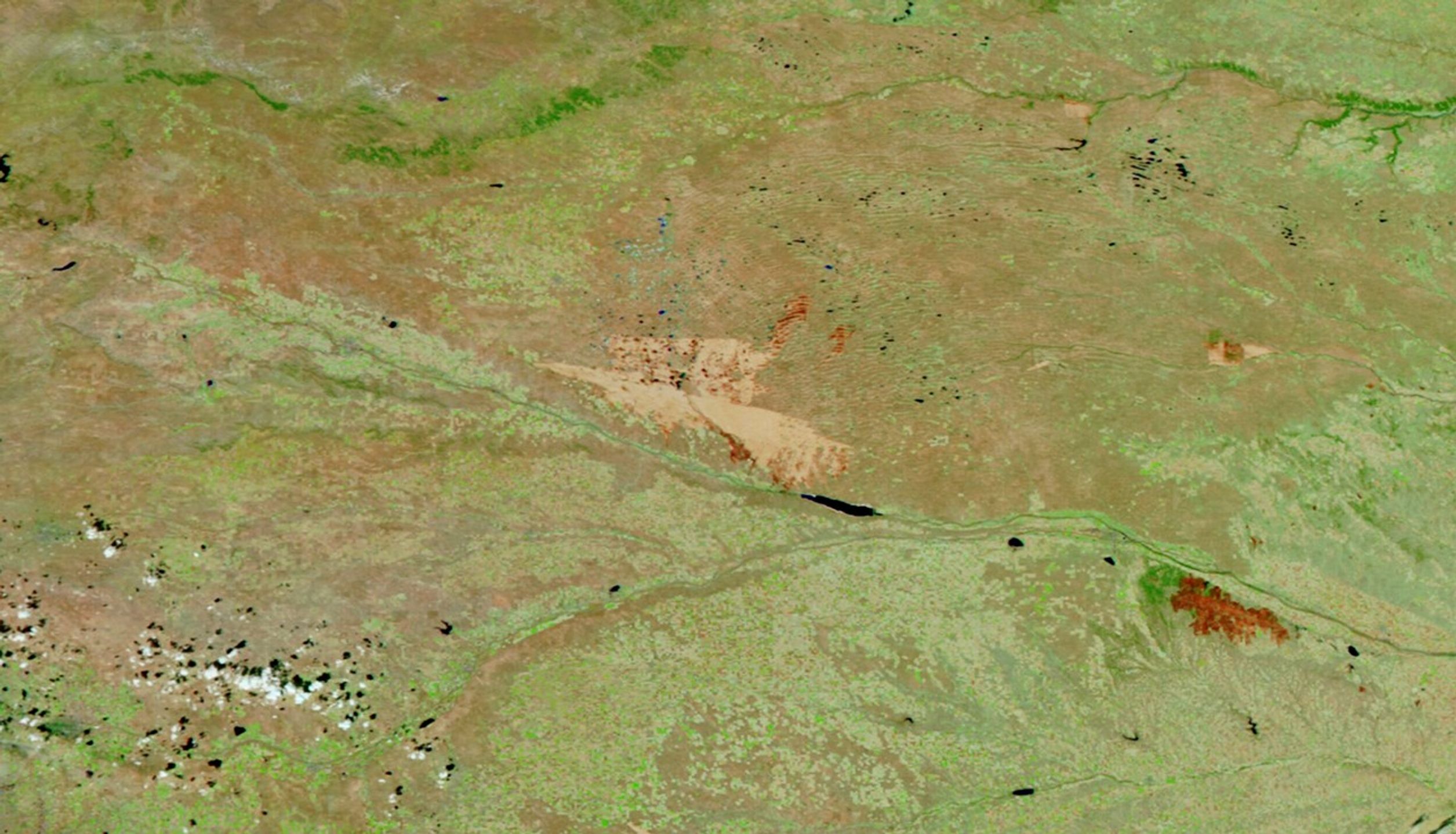 A burned area on the plains of western Nebraska appears as a large tan area in a false-color satellite image.