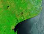 In an image of the same area captured before the flooding on December 17, 2025, a thin line of river water runs down the center of otherwise dry floodplains.
