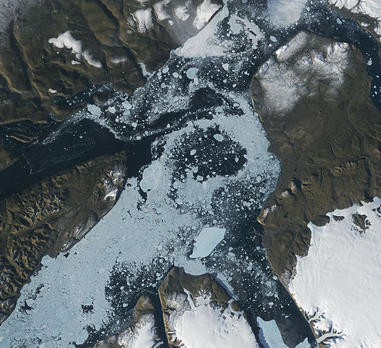 A satellite view shows a large tabular iceberg at the junction of its home fjord and Nares Strait.