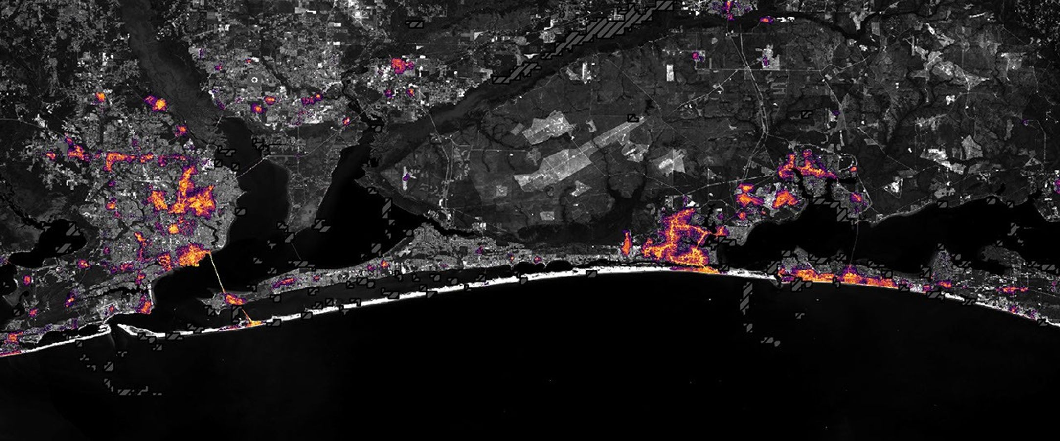 Nighttime lights along the Florida Panhandle coast on October 11, 2026, after Hurricane Isaias, with fewer and dimmer lights in Pensacola and Destin and gaps along the road between them.