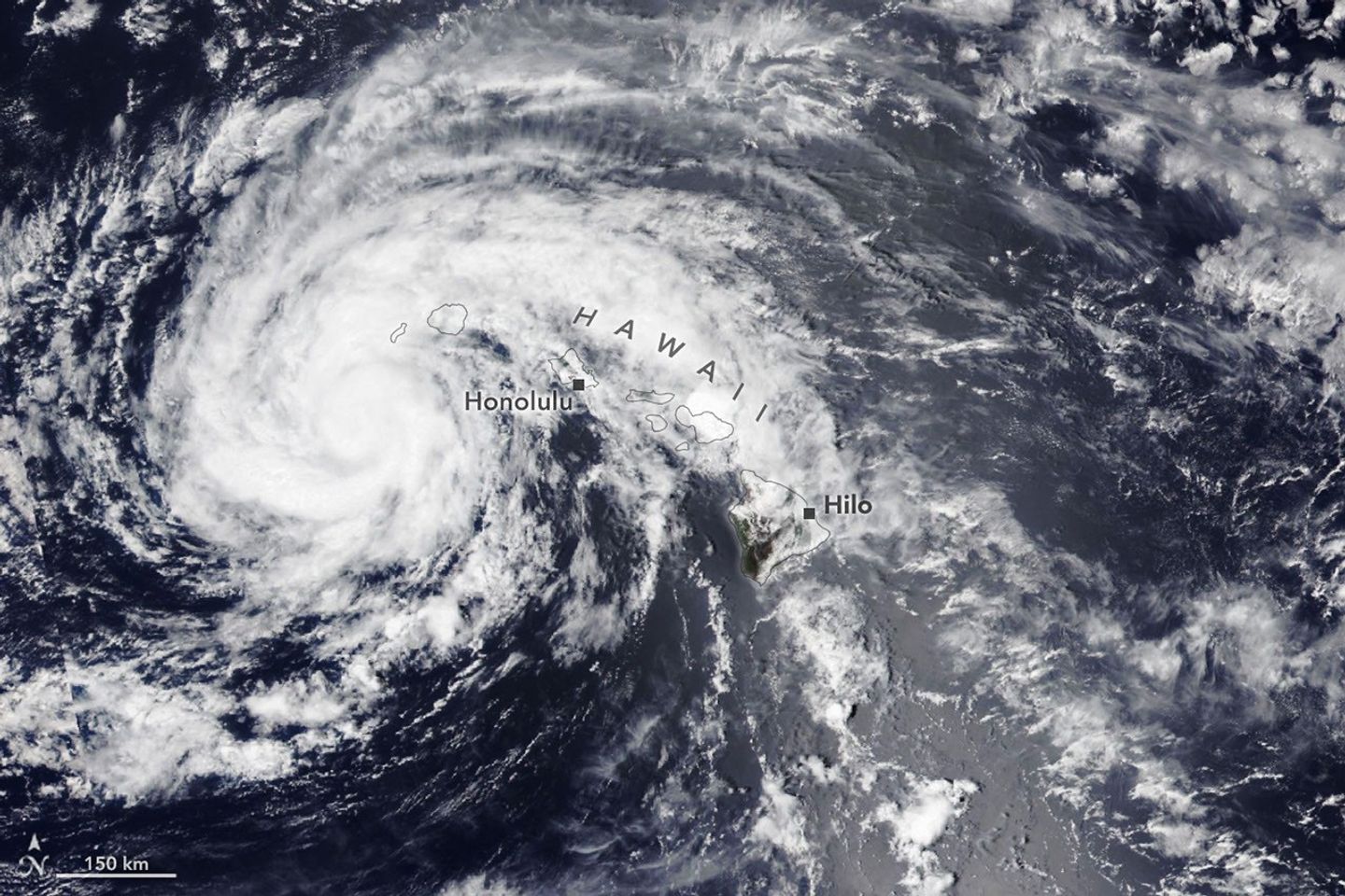 The spiraling clouds of a tropical storm are centered near the Hawaiian island of Kauaʻi.