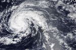 The spiraling clouds of a tropical storm are centered near the Hawaiian island of Kauaʻi.