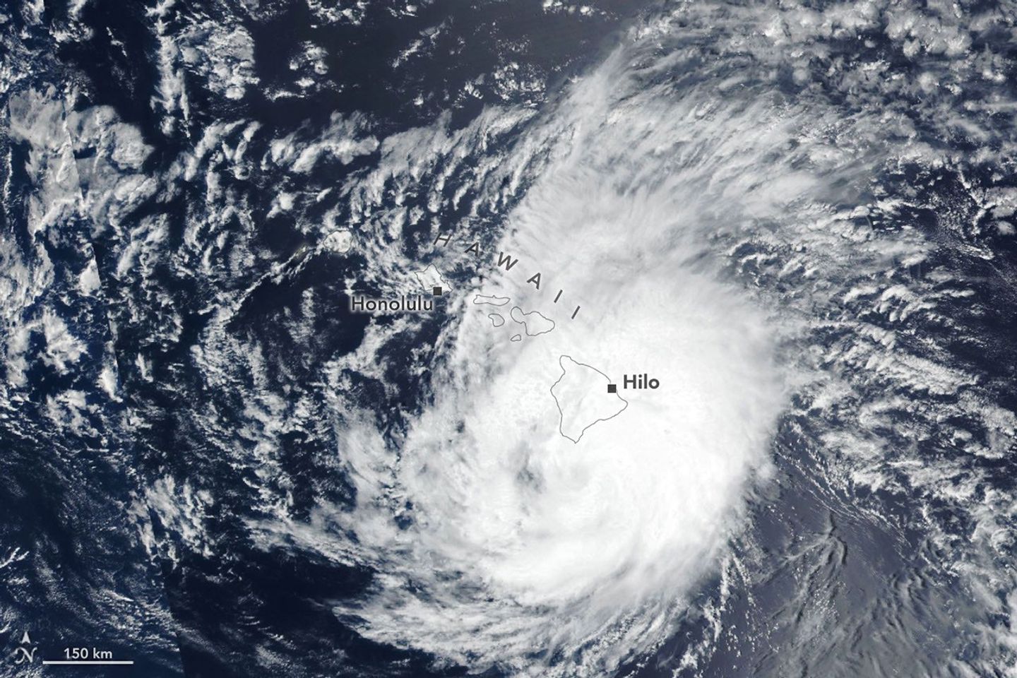 The spiraling clouds of a hurricane appear near the Hawaiian Islands. Its eye is just south of the Island of Hawaiʻi.
