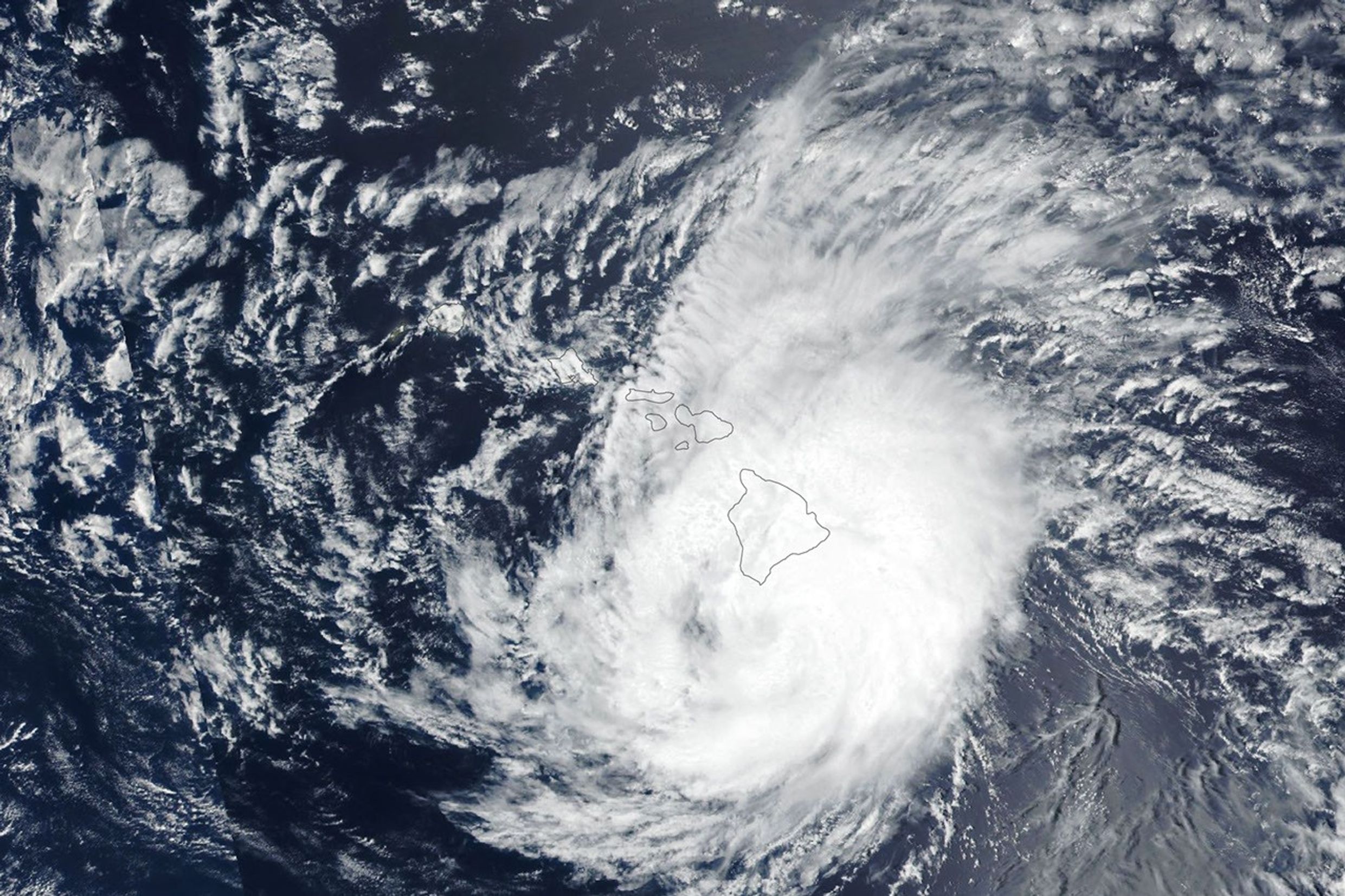 The spiraling clouds of a hurricane appear near the Hawaiian Islands. Its eye is just south of the Island of Hawaiʻi.