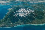 The Olympic Peninsula, viewed at an angle from above, features snow-capped mountains surrounded by deep, forested river valleys. Islands in Puget Sound and developed areas including Seattle and Tacoma appear across the top of the photo.