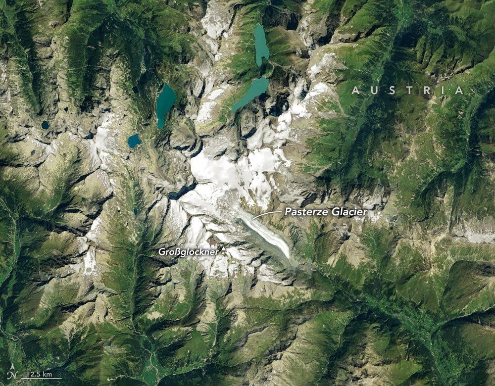 Ice in a broad Alpine basin feeds debris-covered glacial ice several kilometers long in the valley below.