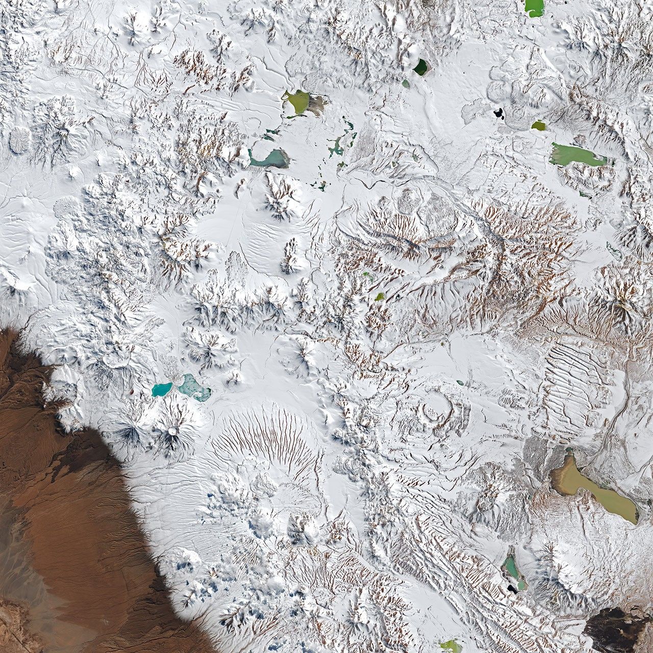 The same plateau is now blanketed in white snow. The location of the radio telescope array is nearly indistinguishable from the surrounding terrain.