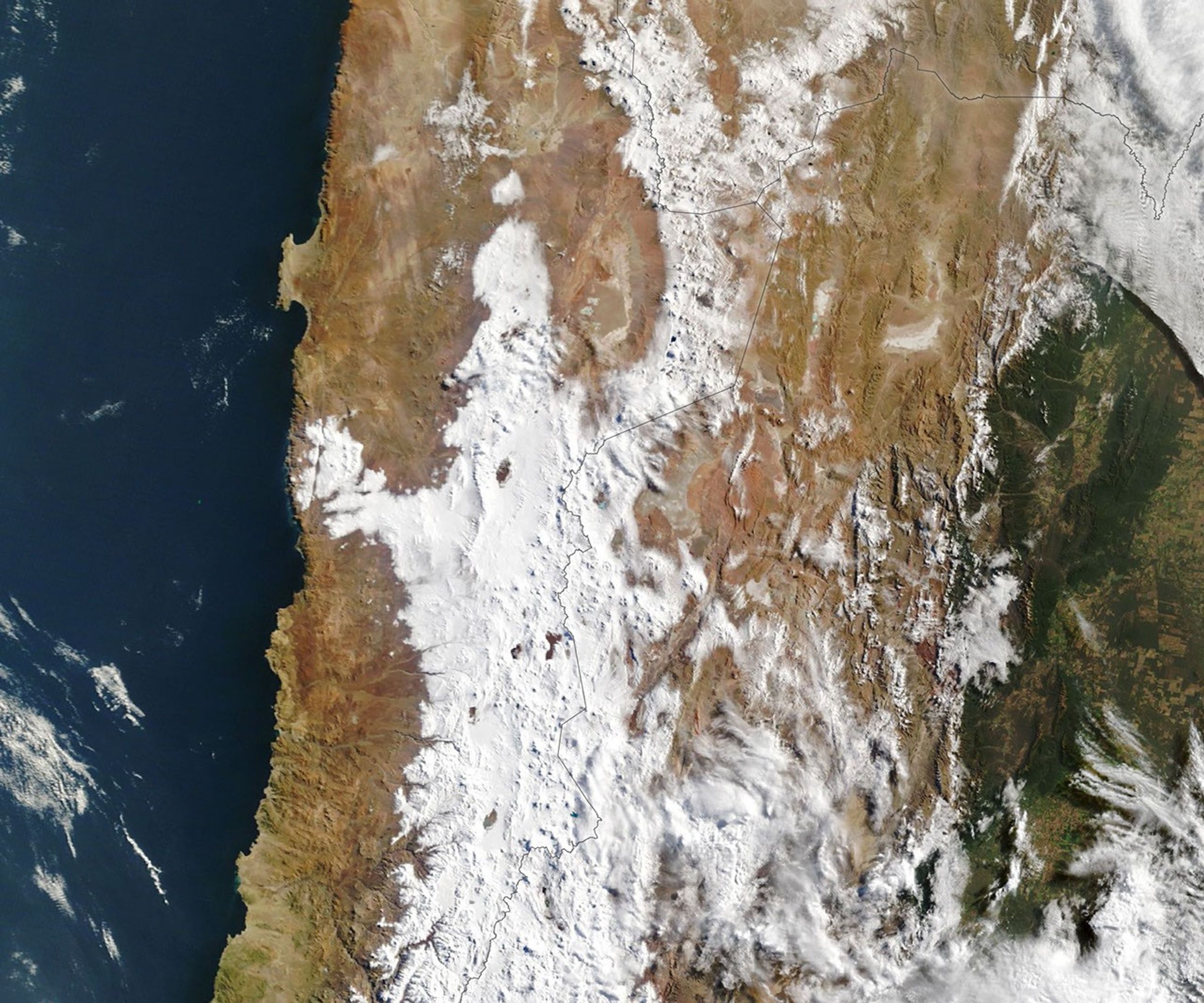 A wide view of northern Chile, Argentina, and southern Bolivia and Peru shows snow cover after a storm, stretching from the Andes into the core of the Atacama Desert. In one spot, a patch of snow reaches nearly to Chile's Pacific coast.
