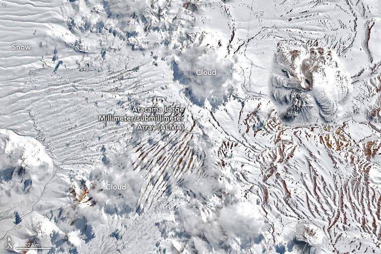 The same plateau is now blanketed in white snow. The location of the radio telescope array is nearly indistinguishable from the surrounding terrain.