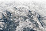 A 3D map shows the town of Cortina d’Ampezzo, Italy, in the foreground with tall peaks in the Dolomites rising behind it. A label indicates the location of the Olympic ski run on a mountain called Tofana di Mezzo. Snow covers the ground in most of the scene.