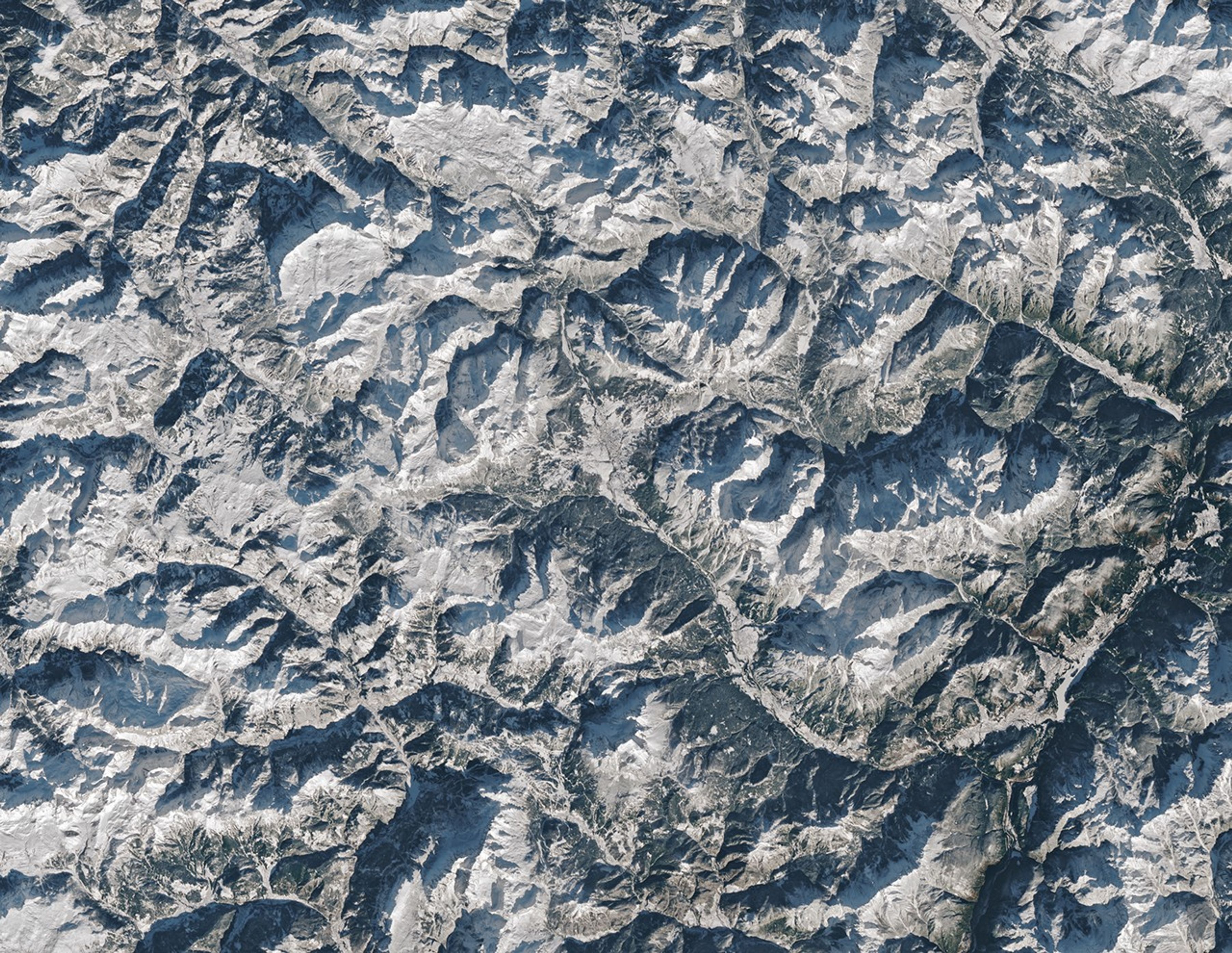 Cortina d’Ampezzo, Italy, co-host city of the 2026 Winter Olympics, sits in a valley surrounded by tall mountains in the Dolomites. Snow covers the ground in most of the scene.