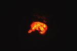 The heat signature from an eruption at Kilauea glows yellow and orange in the volcano’s summit crater.