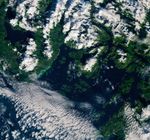 A swath of water along the coast of Vancouver Island appears cloudy and green to turquoise in color.