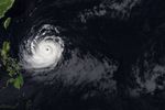 The spiraling clouds of Super Typhoon Bavi appear over the Philippine Sea southeast of Taiwan. The storm’s westward track is shown in colors corresponding to wind speed.