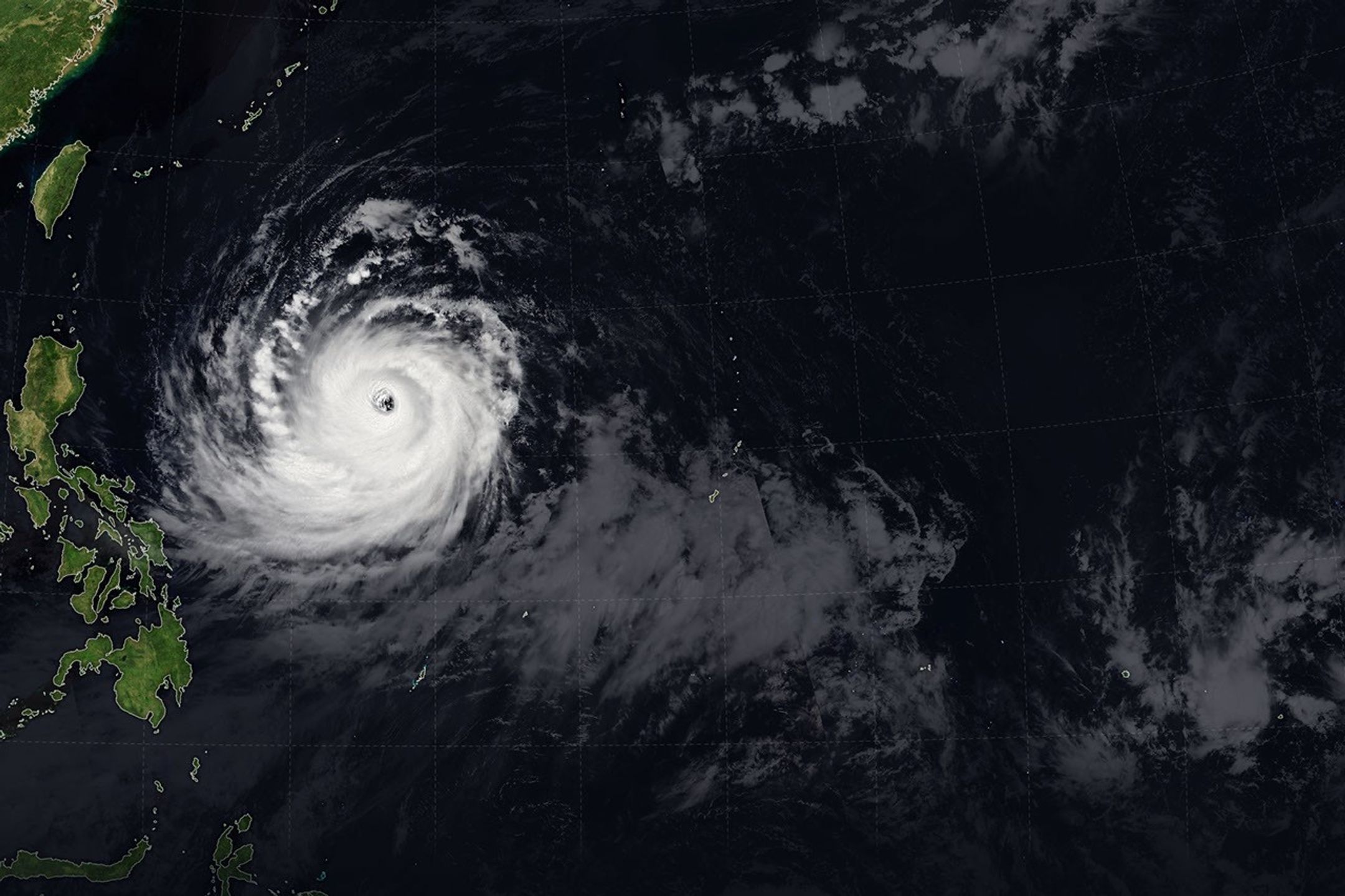 The spiraling clouds of Super Typhoon Bavi appear over the Philippine Sea southeast of Taiwan. The storm’s westward track is shown in colors corresponding to wind speed.