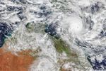 A tropical cyclone with spiraling clouds and a well-defined eye sits off the coast of Queensland, Australia.